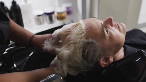 vista trasera mujer con el cabello lavado por un peluquero