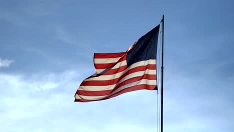 american flag waving against a background of blue sky