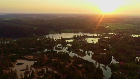 Lake-village-and-vast-countryside-landscape,-aerial-drone-view