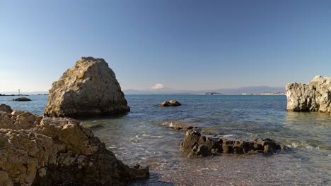 Beautiful-rocky-beach-with-clear-water-and-Mount-Fuji-in-distance