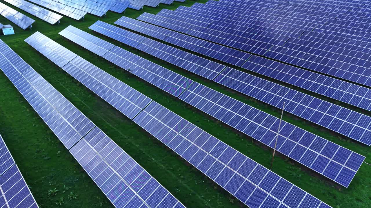 Solar panels cover vast green field in vast renewable energy project