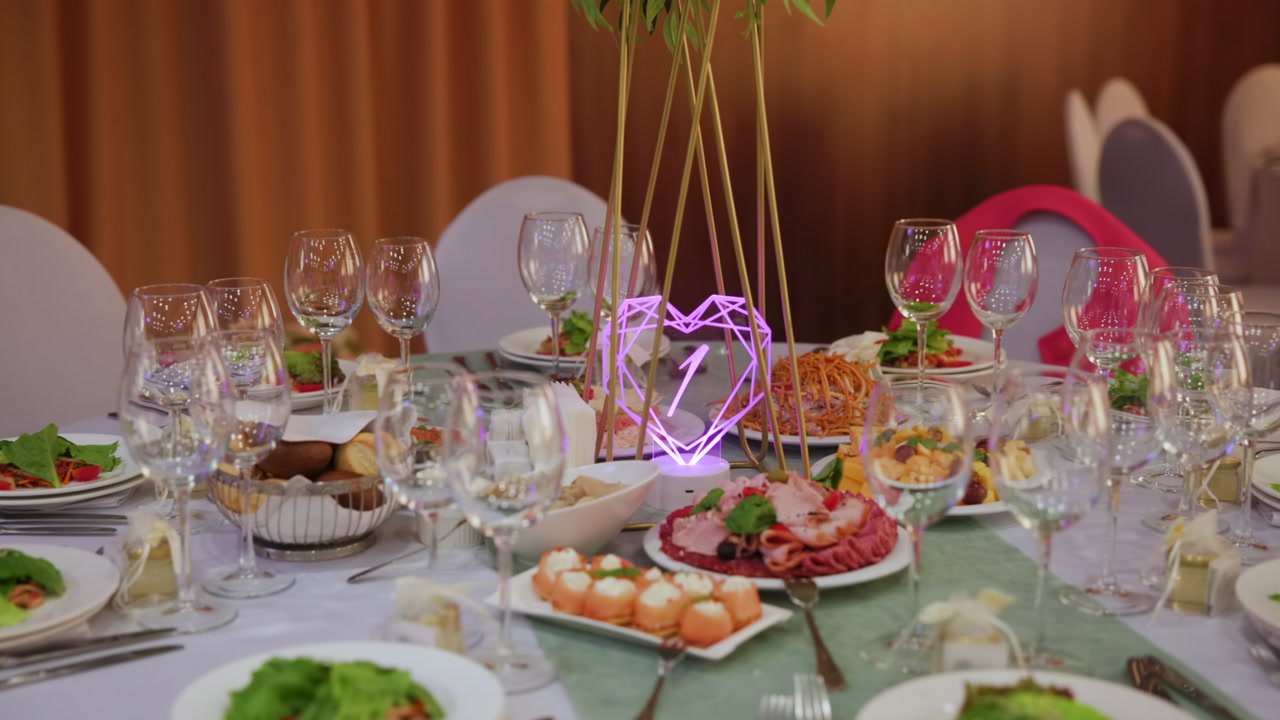 Elegant Banquet Table With Neon Heart Centerpiece, Sparkling Glassware And Crystal Stemware Surround Platters. Creative