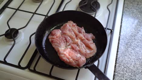 white meat simmering in pan of hot oil