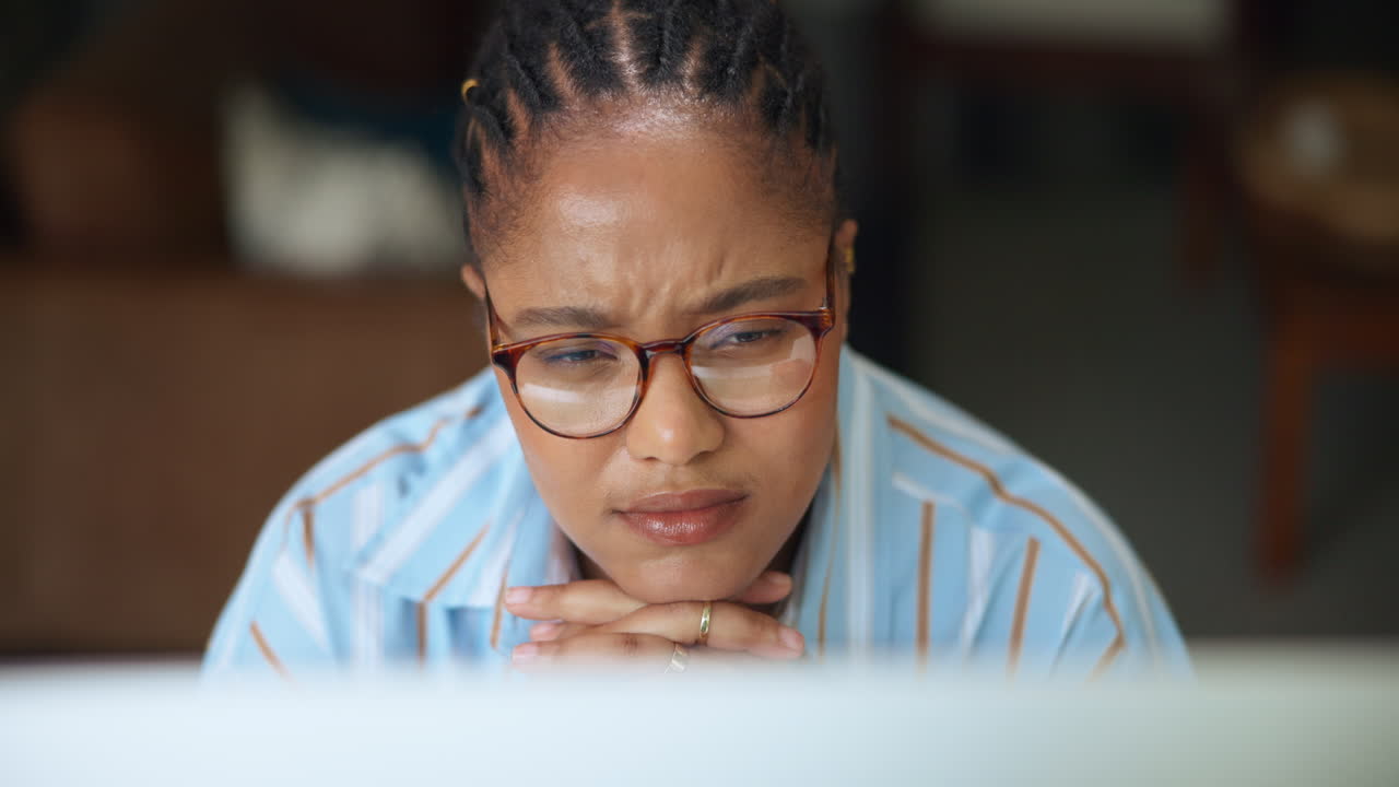 Young African American Woman Concentrating on a Computer Screen