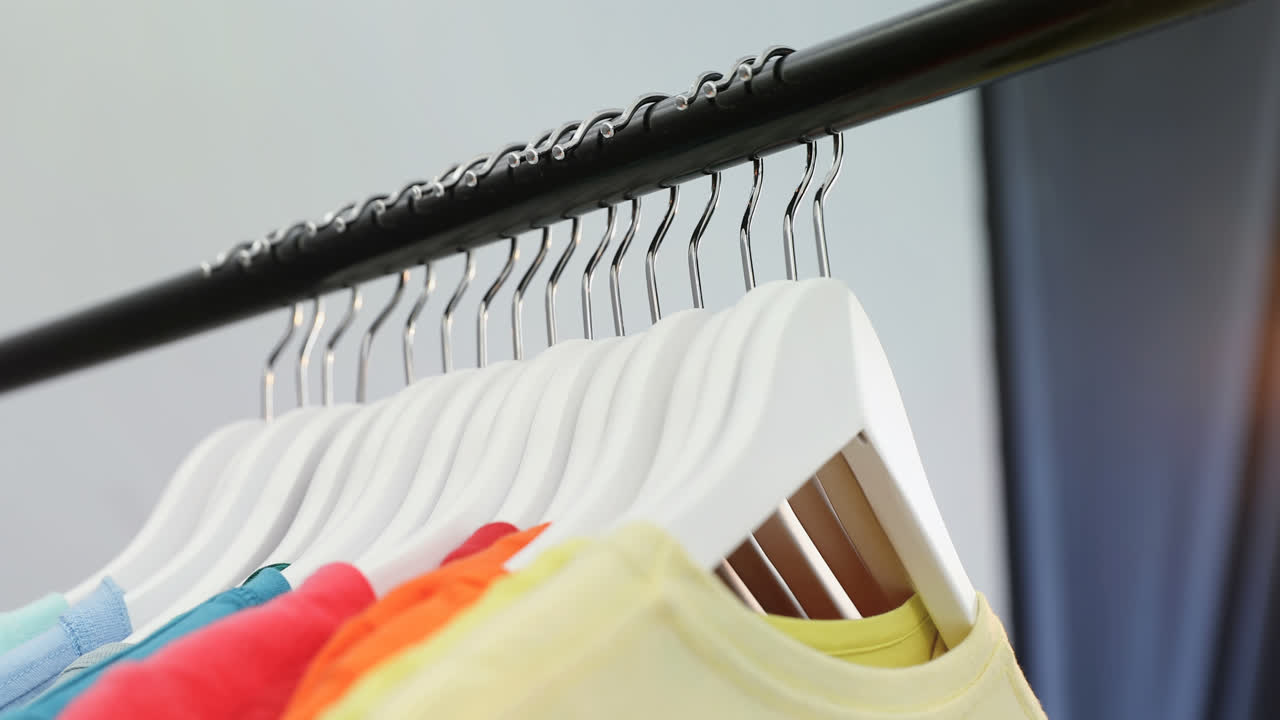 varias camisetas dispuestas en una fila en un estante de tela 4k