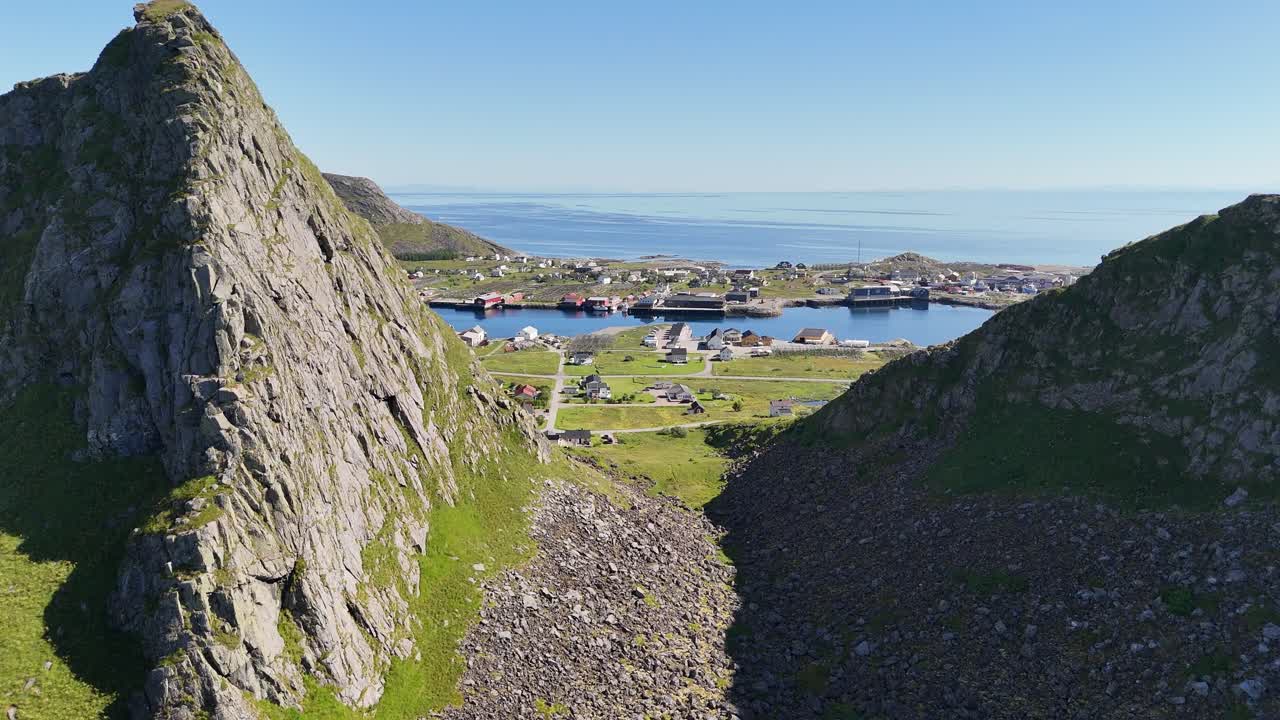 Drone flight over Værøy: soaring through dramatic mountains, revealing the village below, the ocean and distant Lofoten islands
