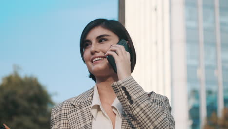 una mujer elegante haciendo una llamada de negocios al aire libre.