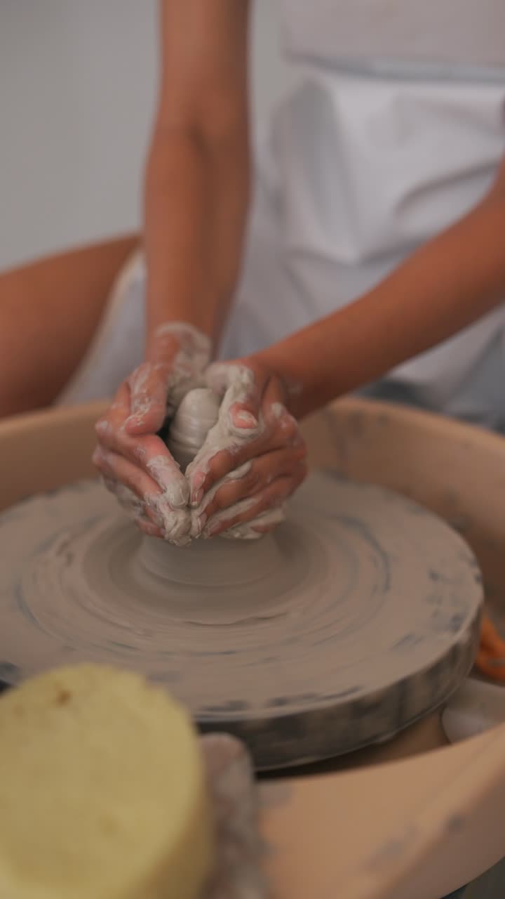 manos moldeando arcilla en una rueda de cerámica