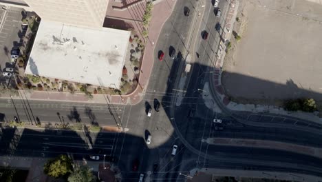 Intersection-in-downtown-Tucson,-Arizona-with-traffic-and-drone-video-overhead-looking-down-and-tilting-up