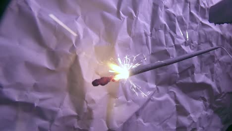 primer plano de la luz de fuegos artificiales bengala y un fondo de papel rayado