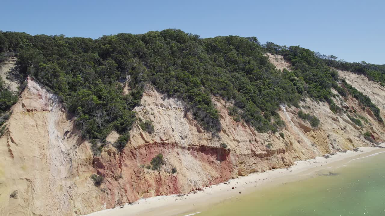 vista panorámica de los acantilados ricos en minerales con vegetación y mar turquesa en la playa del arco iris en cooloola, qld, australia