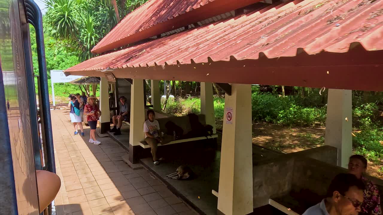 Train approaches and leaves a rural Thai station