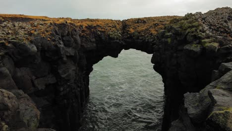 the beautiful black arch rock formation at diamond beach by the sea in iceland - wide shot