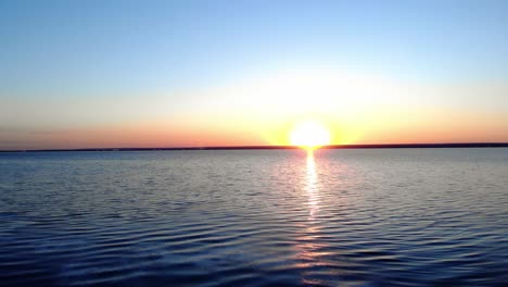 leuchtendes sonnenlicht bei tagesanbruch über einem idyllischen see mit einem holzboot vor der küste