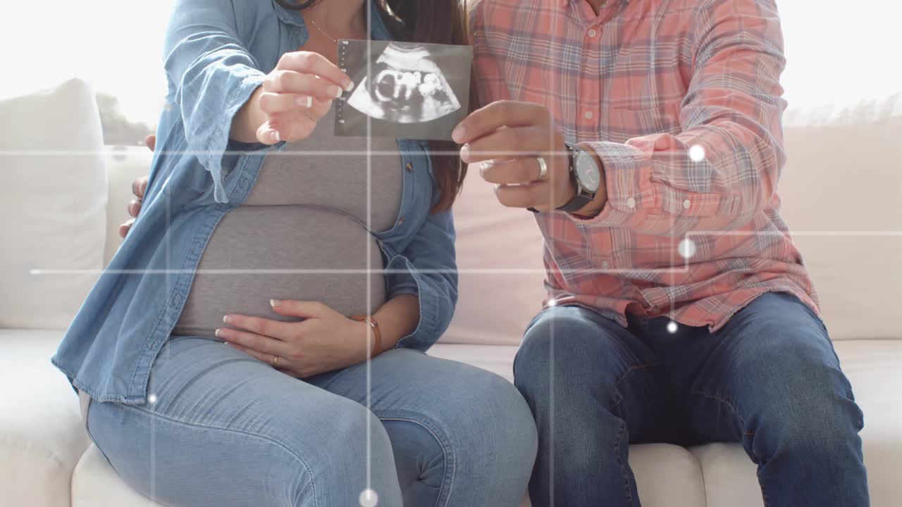 Expecting mom pulling ultrasound print, partner leaning, dot overlay on print, sharing baby news