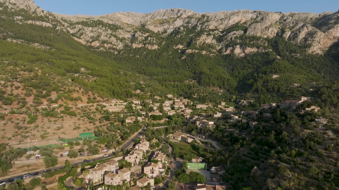 Drone flying towards old mountain village of Deia on Mallorca, Spain
