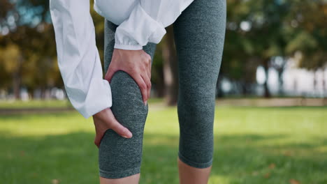 Knee-pain,-injury-and-hands-of-woman-in-a-park