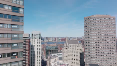 forwards fly between high rise office buildings in city. revealing panoramic view of charles river. boston, usa