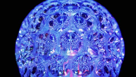 spinning led disco ball glowing neon lights in dark. close-up. 4k