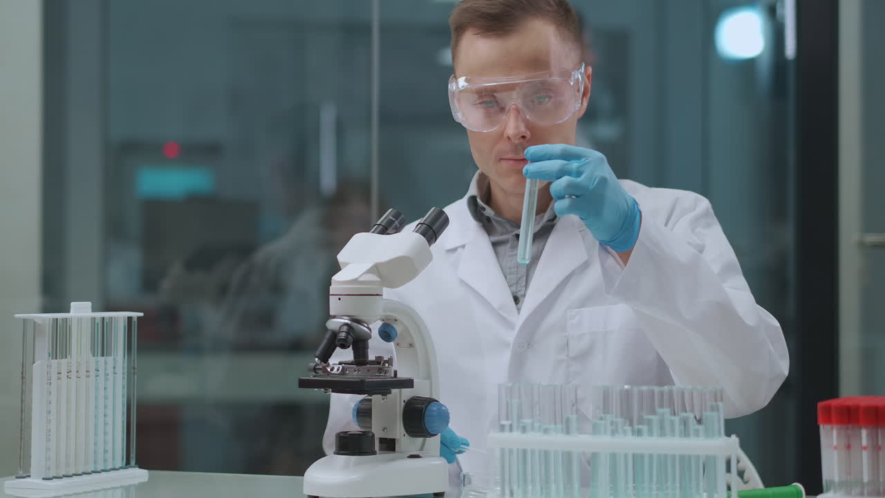 тестирование на ковид-19 в лаборатории техник-мужчина проводит пцр и серологические тесты с использованием труб с образцами и микроскопом здравоохранение и пандемия коронавируса