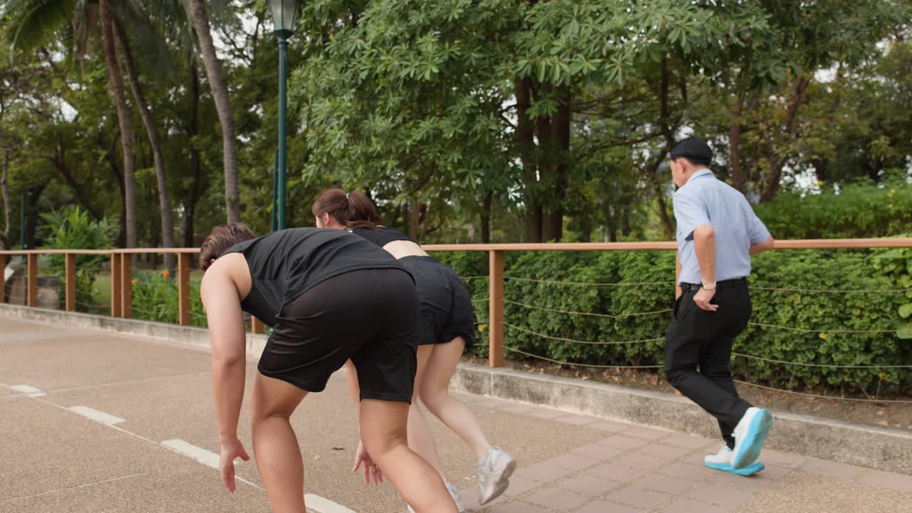 Um casal asiático de camisetas regatas pretas começa a correr a partir de uma posição agachada em Bangkok
