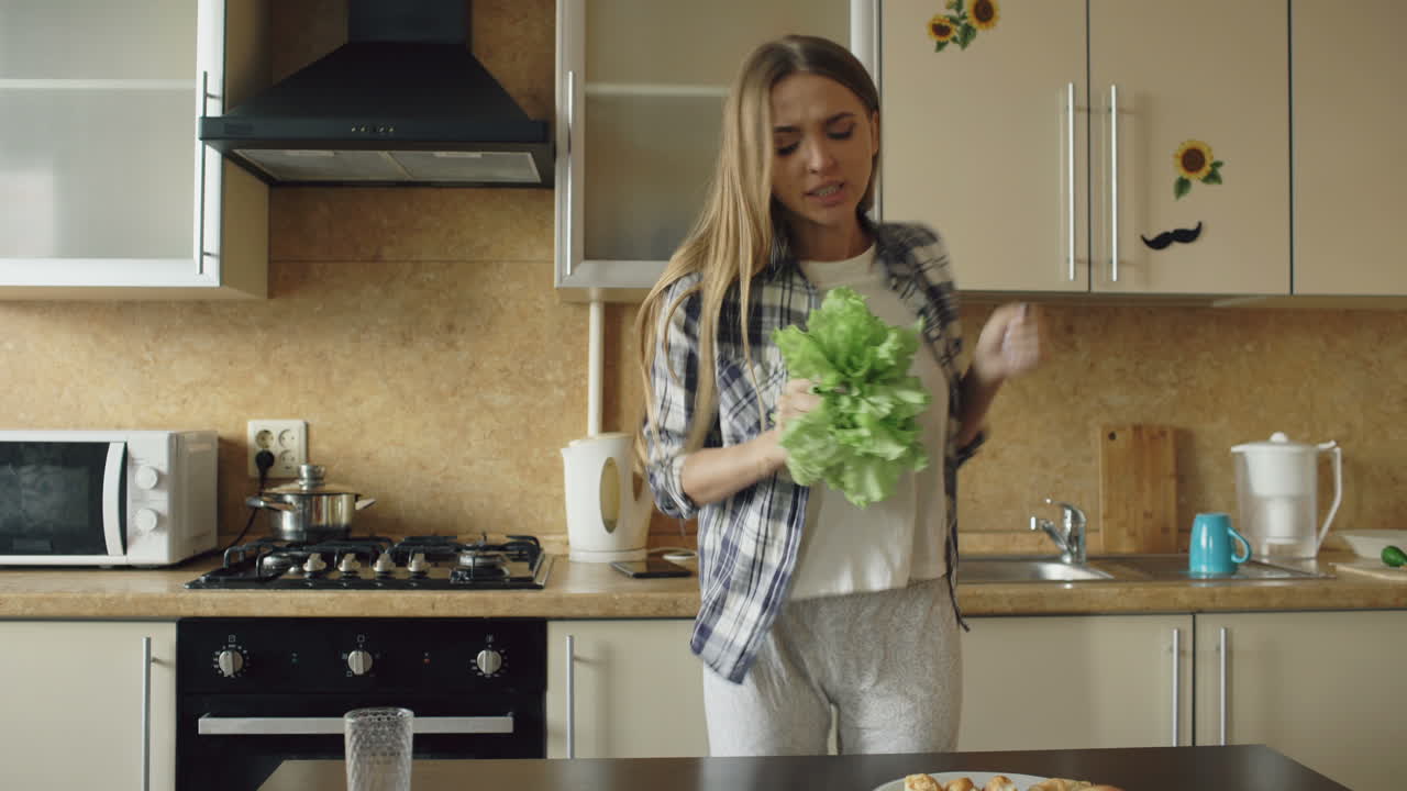 Woman Dancing in Kitchen with Salad