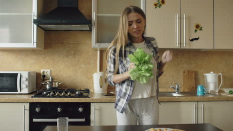 woman dancing in kitchen with salad