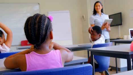 maestra asiática que enseña a los escolares en el aula de la escuela 4k