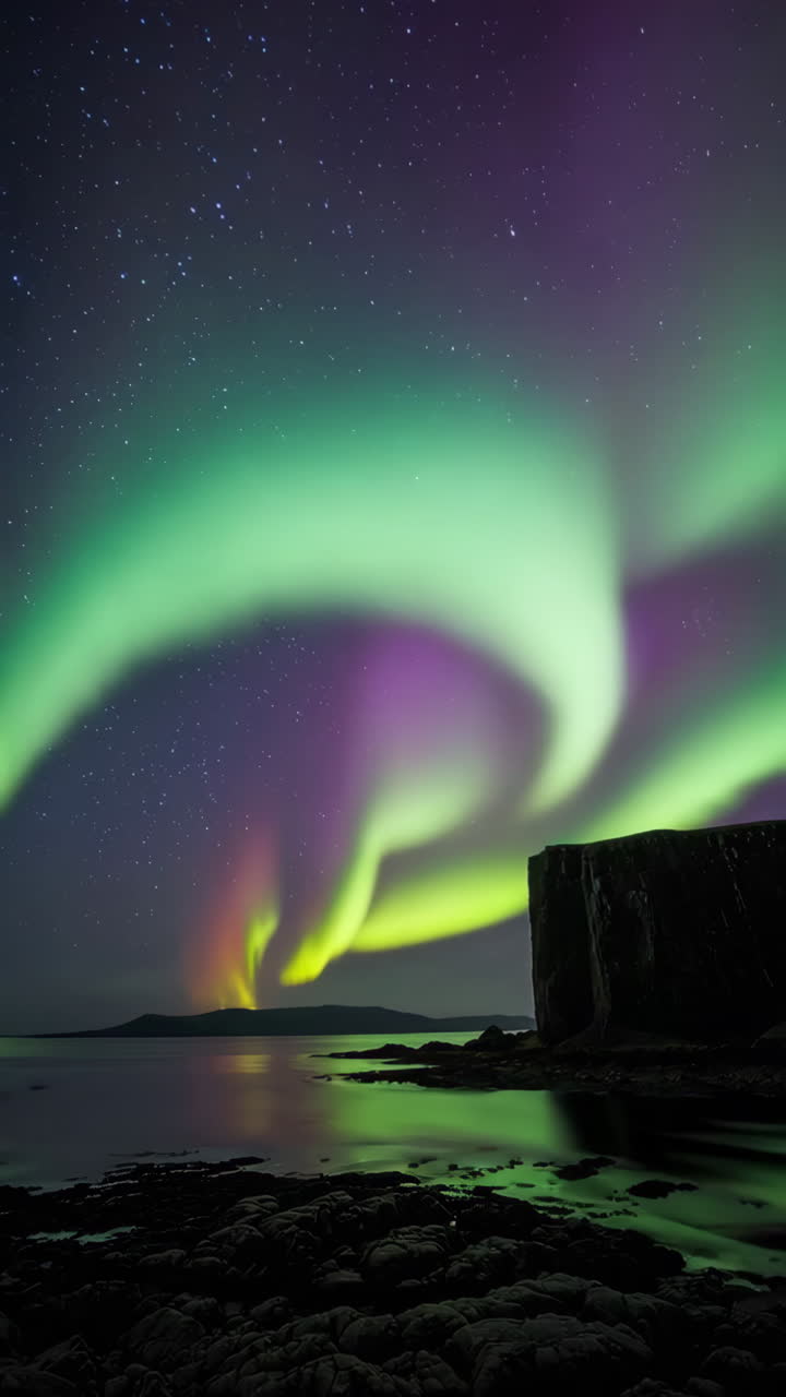 Vibrant Aurora Borealis Display Over Water and Landscape