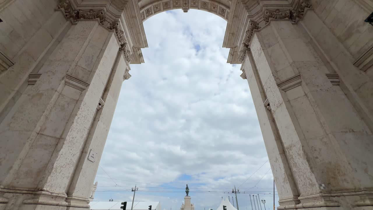 Magnificent details of the architecture and Tourists taking photos of Rua Augusta Arch in Lisbon, Portugal. Tilt-down shot.