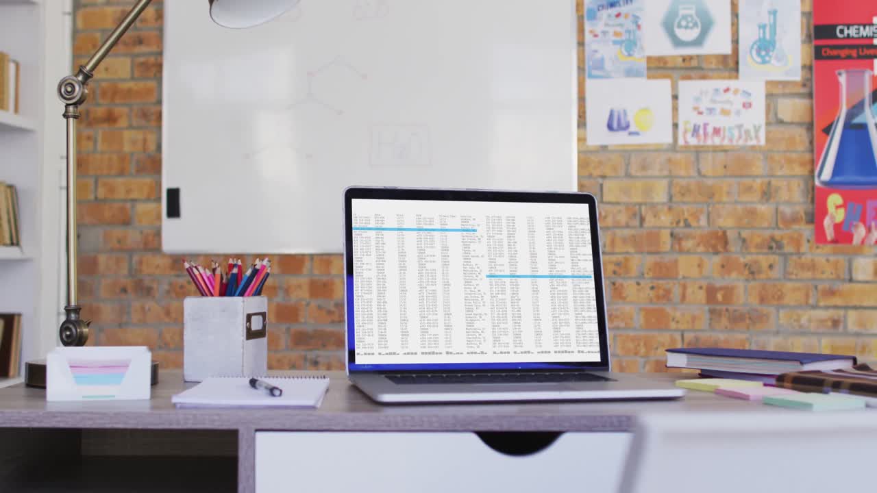 Laptop with data processing standing on desk in office