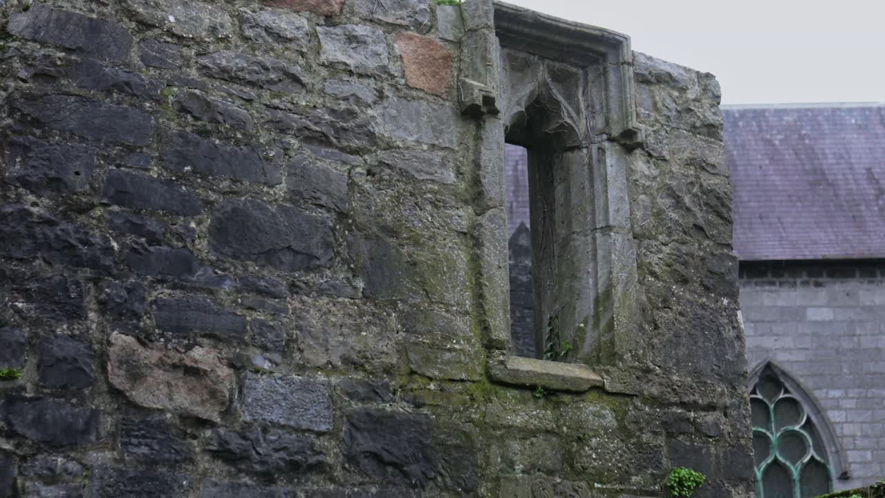Um close-up detalhado da janela e parede de calcário envelhecido da Janela Memorial Lynch em Galway, um monumento gótico do século XV, Irlanda