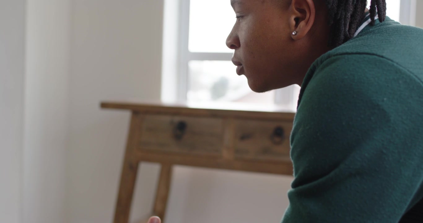 Man clasping hands, leaning forward while camera pulling back, listening at home, watch, copy space