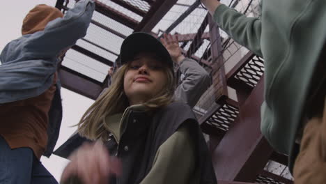 Young-friends-listening-to-music-on-the-stairs