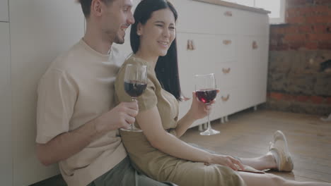 couple enjoying wine in kitchen