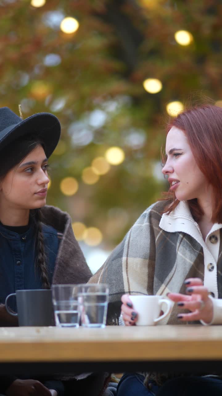 dos mujeres hablando y disfrutando de bebidas al aire libre
