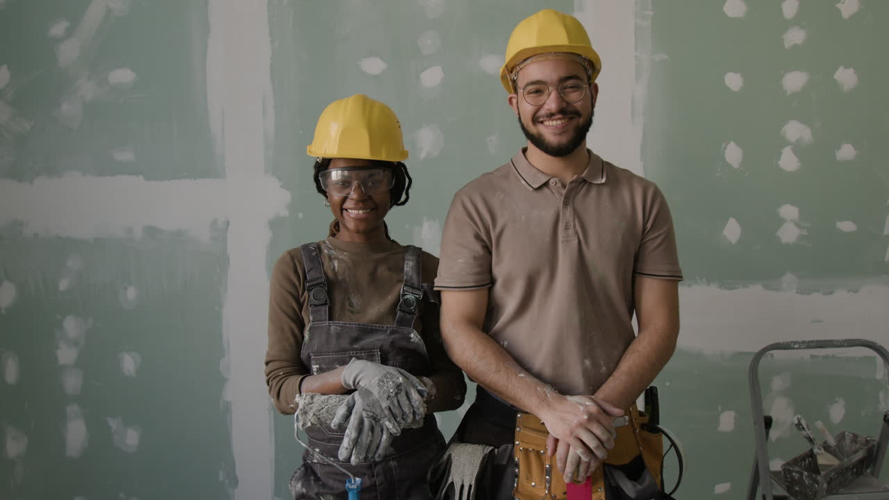 Construction workers in front of drywall