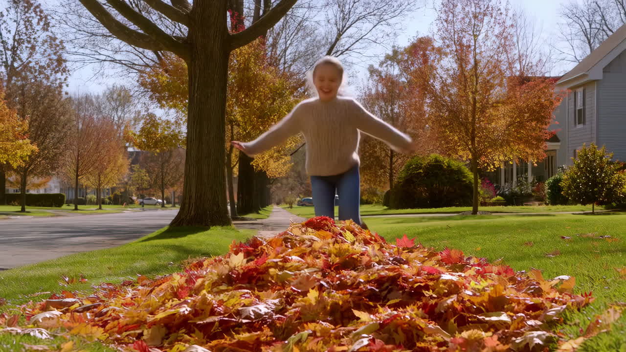 A Young Girl Jumps into a Pile of Autumn Leaves