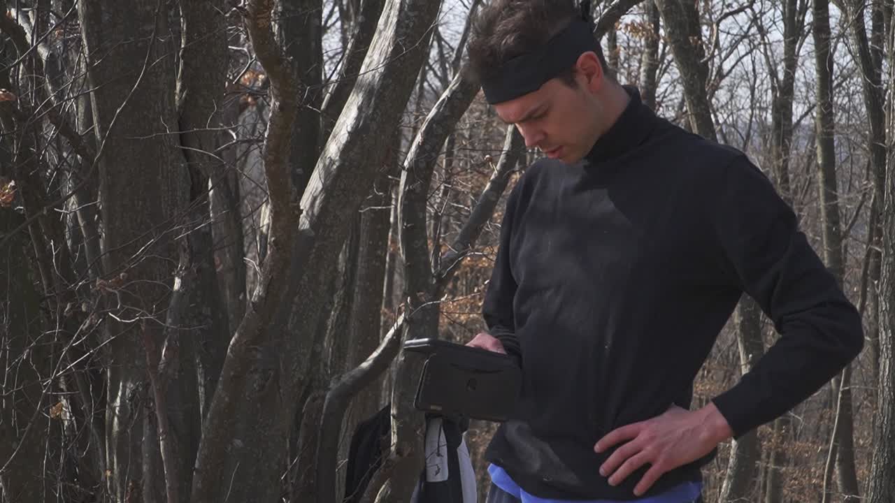 A striking image of a solitary figure clad in contrasting black and blue, set against a tranquil, leafless forest. Ideal for introspection, adventure, and outdoor campaigns.