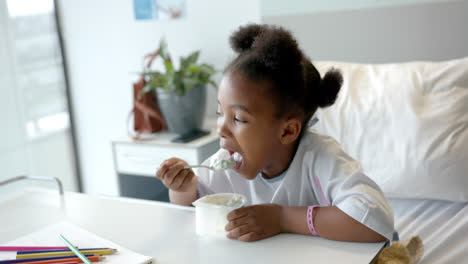 African-american-girl-eating-lunch-in-hospital-bed,-slow-motion