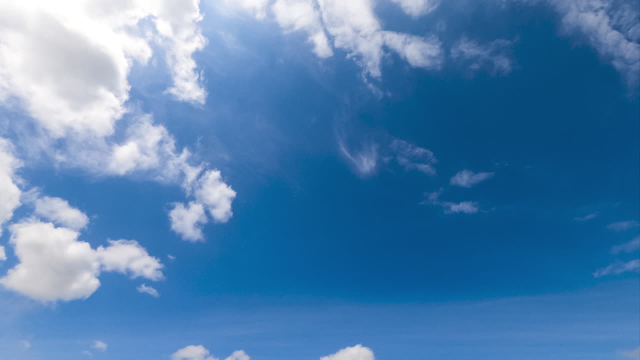 Ethereal white fluffy clouds moving by the sky. Sunny summer day sky timelapse. Low angle view.