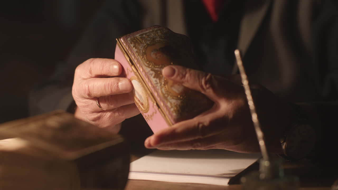Older passionate man evaluates an old porcelain box