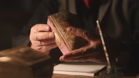 older passionate man evaluates an old porcelain box