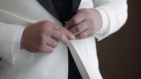 abotonando la chaqueta, el hombre en traje ata los botones de su chaqueta preparándose para salir