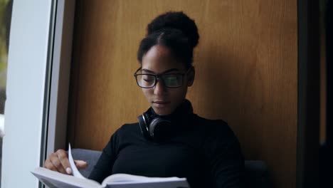 La-Joven-Mujer-Atractiva-Está-Leyendo-El-Libro-En-El-Alféizar-De-La-Ventana-Ancha