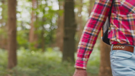 woman leading man as active retired senior couple walk in woodland countryside together