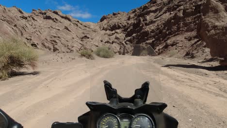 moto pov: motociclista viaja solo en el estrecho cañón de piedra arenisca de badlands