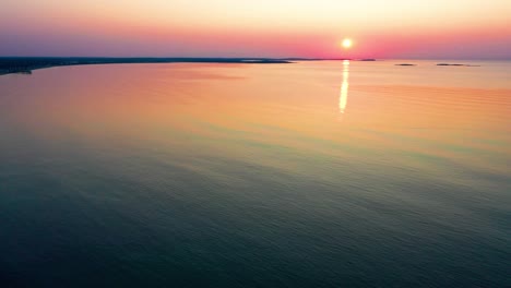 colorful beach sunrise in saco, maine with bright colors reflecting off calm rippling ocean waves along the new england atlantic coastline