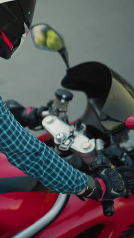 una mujer monta una bicicleta eléctrica roja a lo largo de un camino liso y asfalto, su camisa a cuadros flota en el viento, exponiendo parte de su torso mientras se inclina hacia adelante