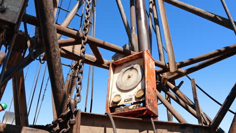pipes, chains and control desk at the drilling site. equipment for natural resources production. low angle view.